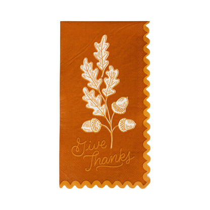 Burnt Orange napkin with white leaf and acorn design and 'Give Thanks' text with a scalloped edge trim.