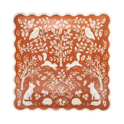 Decorative square rust-colored paper plate with white forest animals and plants pattern.
