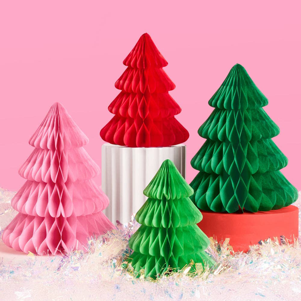 Four paper Christmas trees in red, green, and pink on a pink background