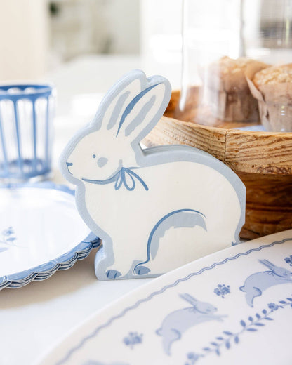 White bunny-shaped placemat with blue details on a table setting.