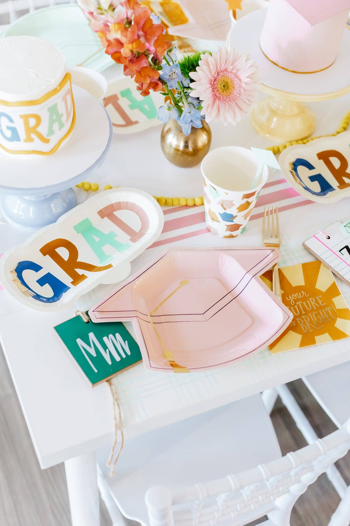Graduation-themed party supplies including plates, cups, and napkins on a table.