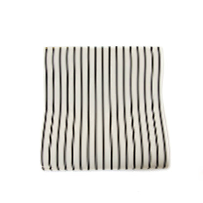 Striped cream colored paper table runner with black stripes on a white background.