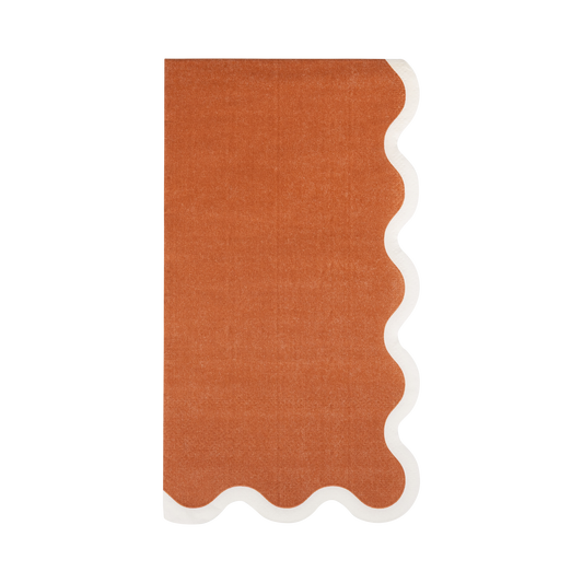 Rectangular rust orange paper napkins with a white scalloped edge.
