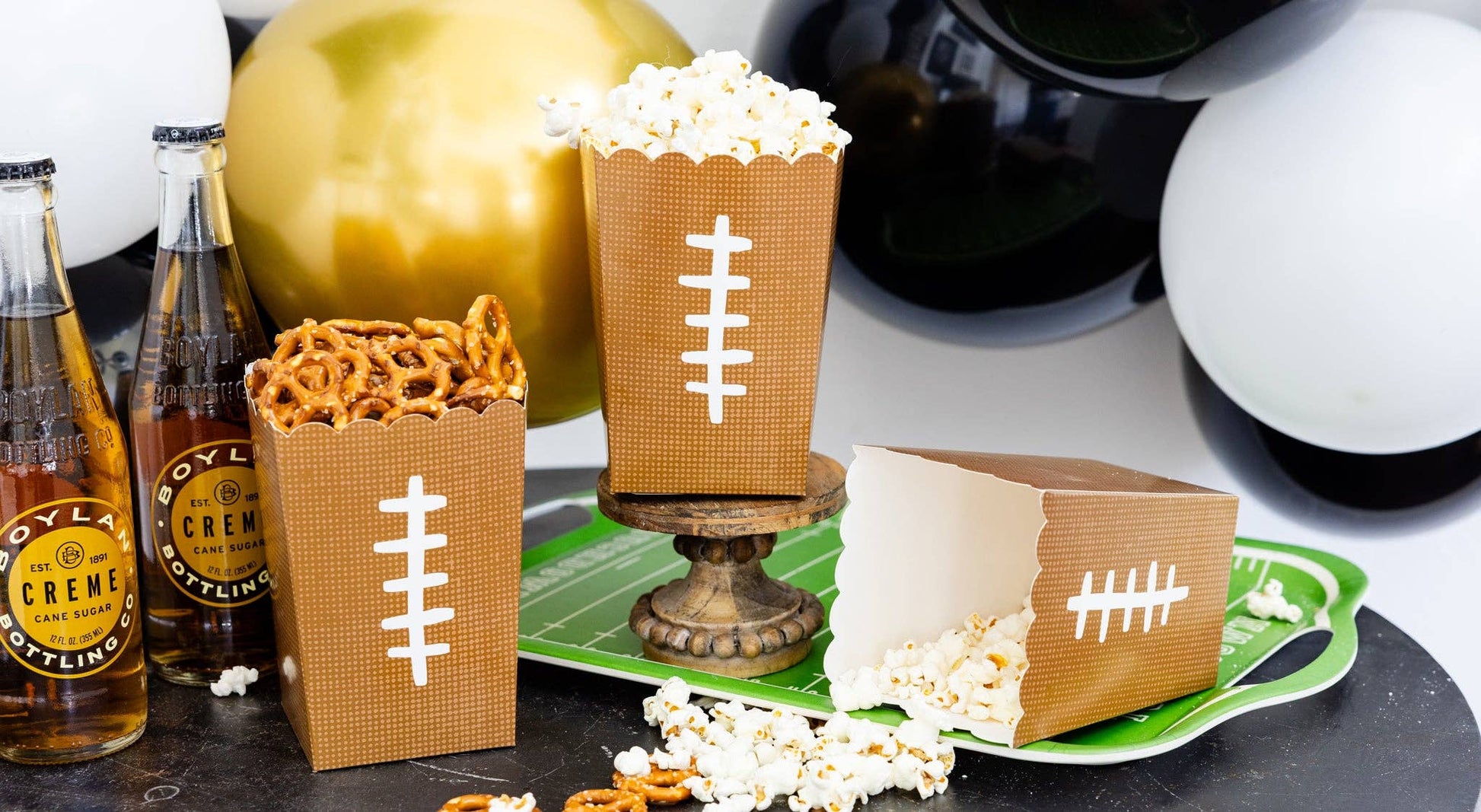 Football-themed snacks and drinks on a table with decorative elements.