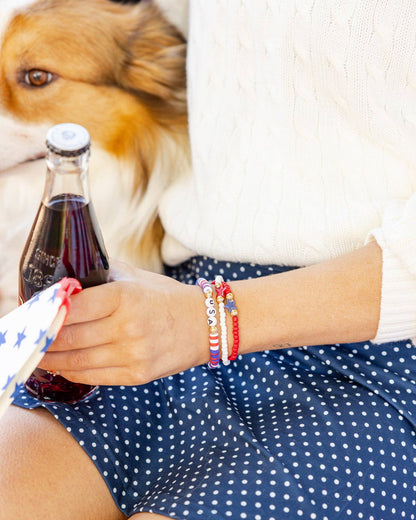 Person holding a bottle of pop with a dog in the background