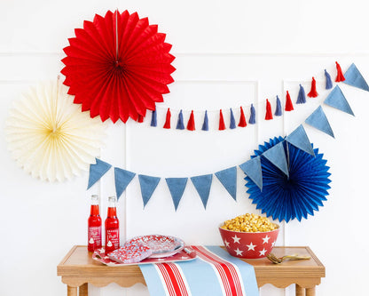 Decorative setup with red, white, and blue paper fans and flags on a table.