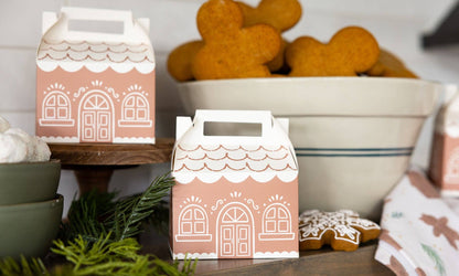 Gingerbread-themed treat boxes with cookies and a bowl in the background