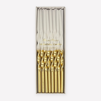 Set of gold birthday candles in a branded box on a white background