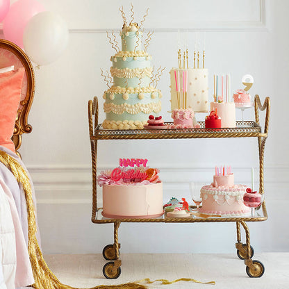 Decorative birthday cake on a gold cart with a white background
