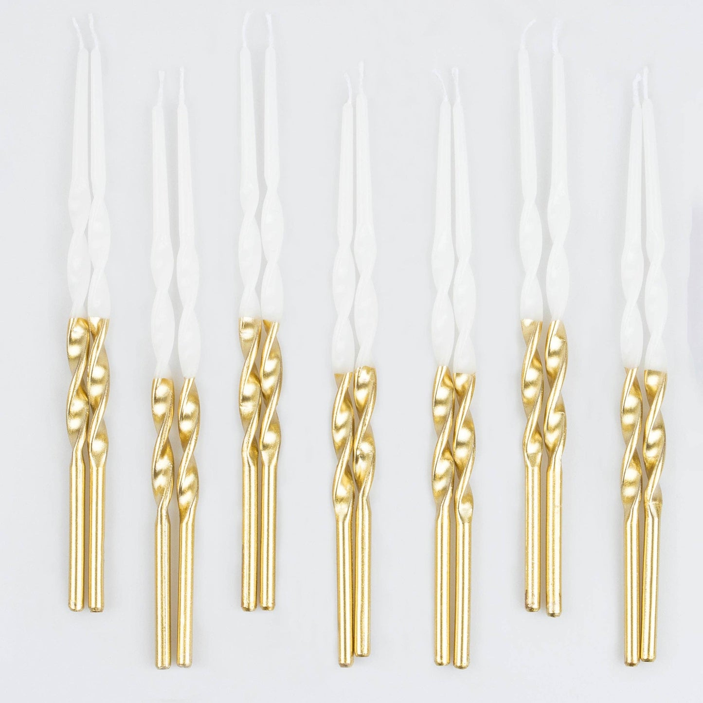 Gold dipped spiral birthday candles on a white background