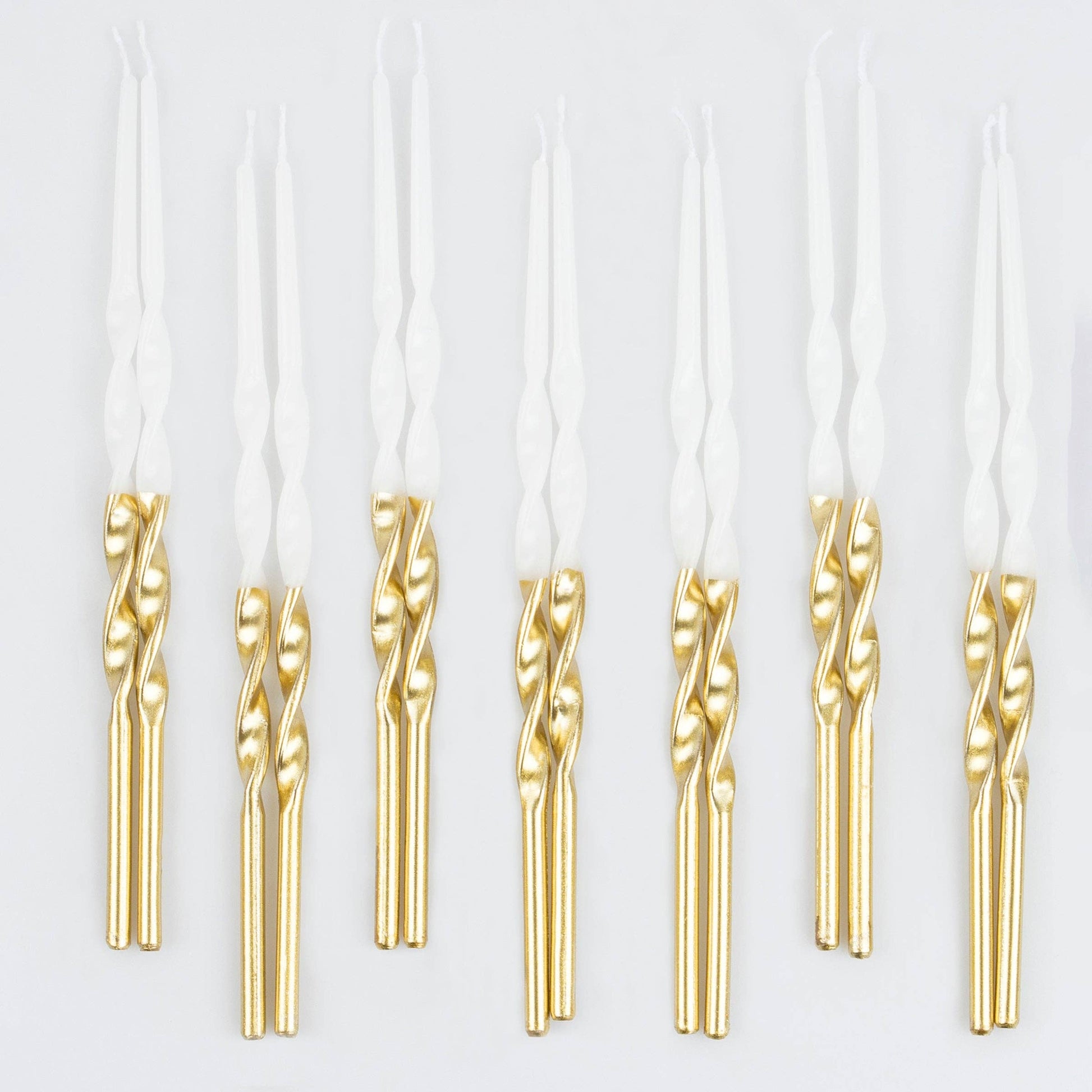 Gold dipped spiral birthday candles on a white background