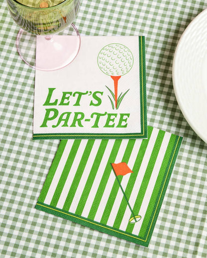 Two napkins with golf-themed designs on a green checkered tablecloth.