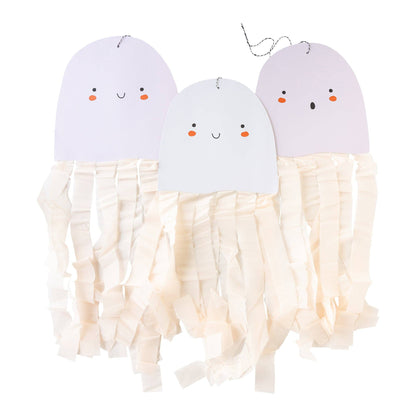Three paper ghost-shaped hanging decorations with smiling and surprised faces with dangling white crepe paper