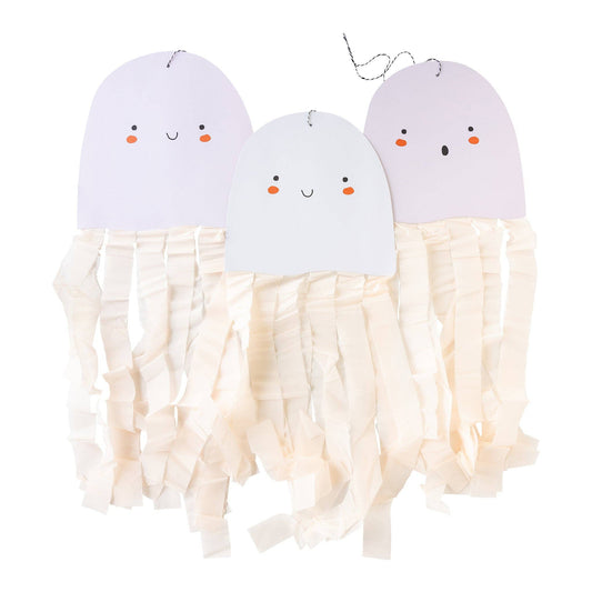 Three paper ghost-shaped hanging decorations with smiling and surprised faces with dangling white crepe paper