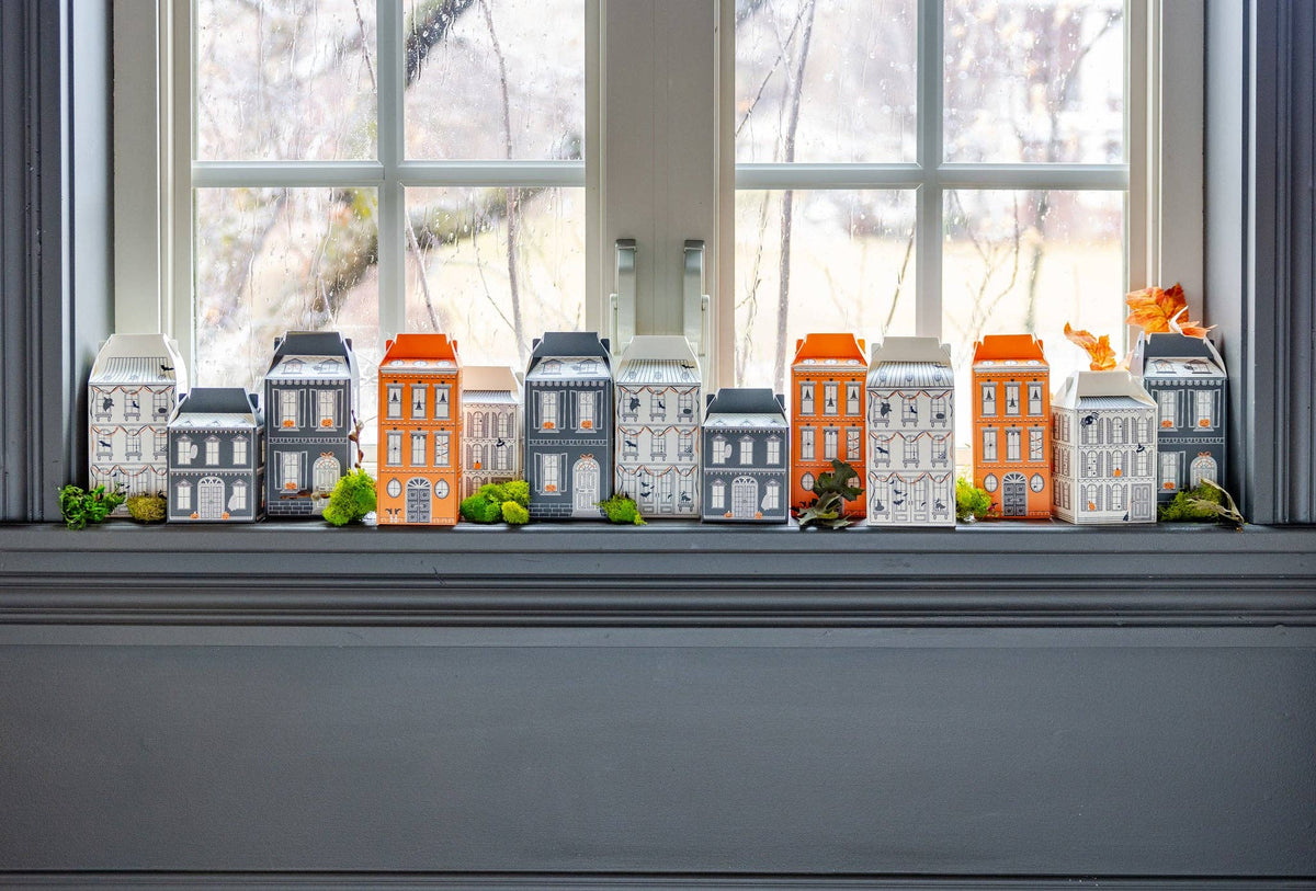 Halloween Village House Treat Boxes on a windowsill with a rainy landscape outside