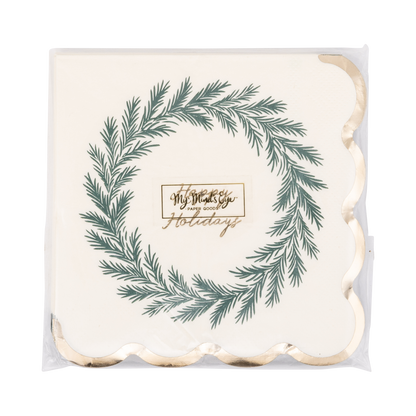 A set of square white paper napkins with scalloped edges, wrapped in clear plastic. The napkins feature a green pine wreath illustration and the gold foil text 'Happy Holidays' in the center.