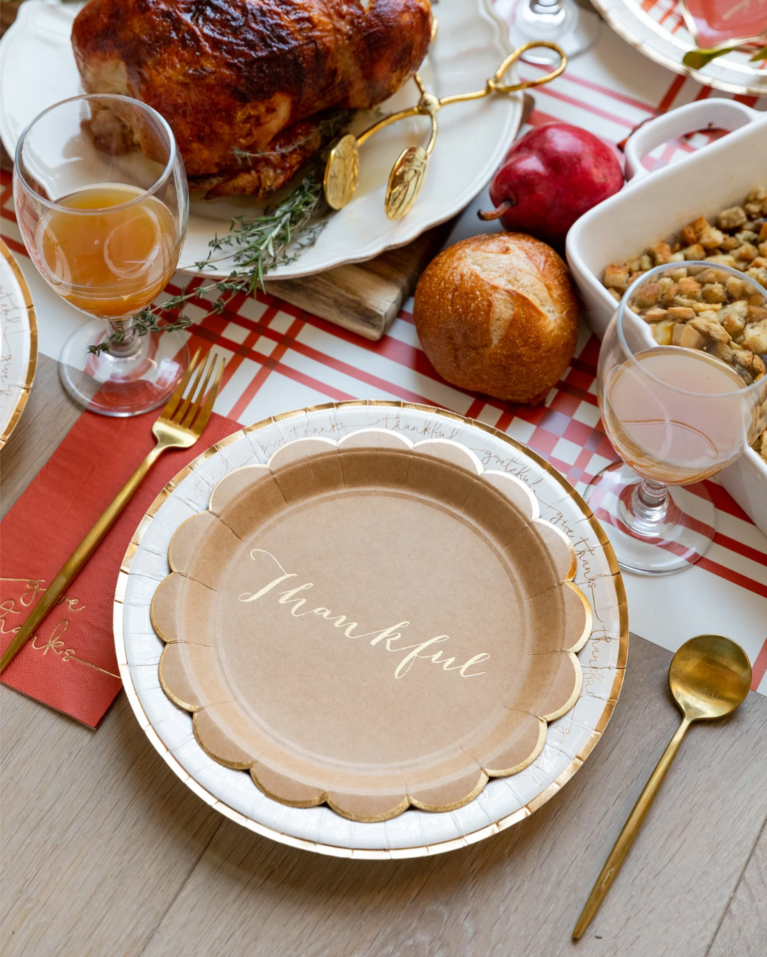 Thanksgiving table setting with a 'thankful' plate, roasted turkey, and side dishes.