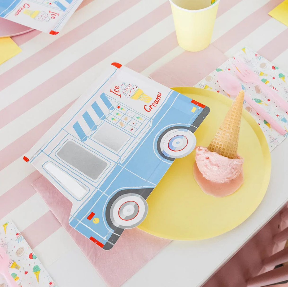 Ice cream truck-shaped paper plate with ice cream cone on a striped tablecloth
