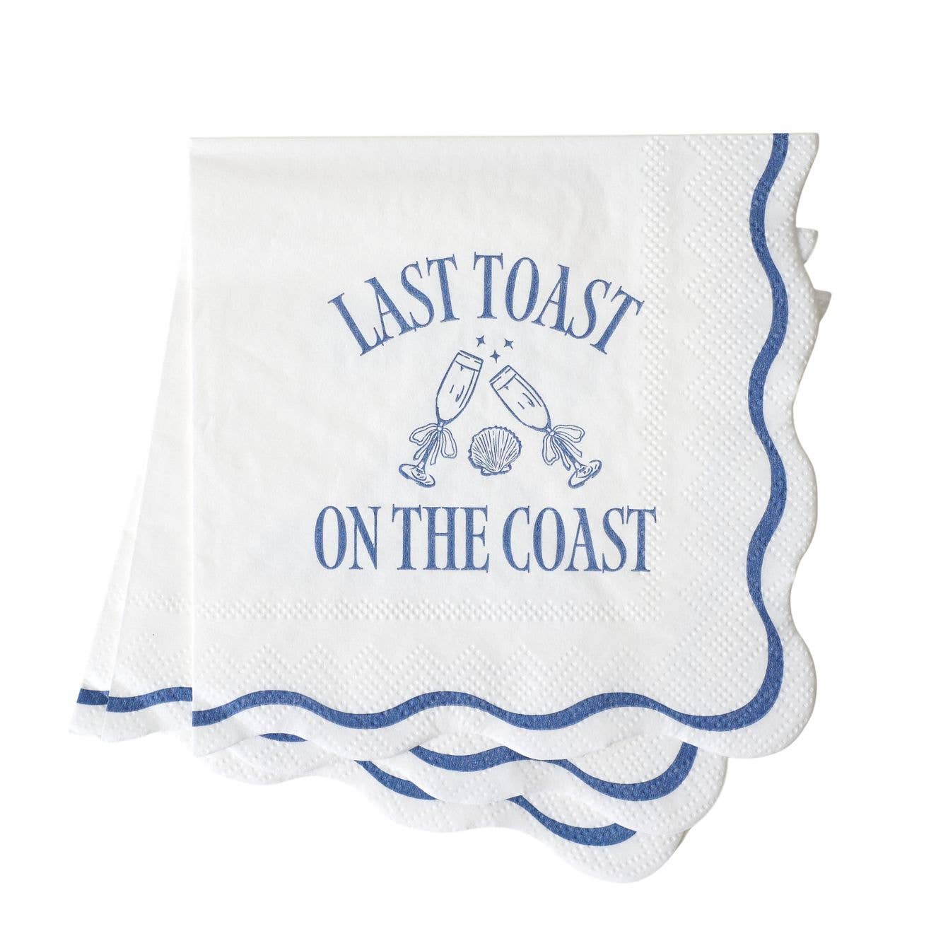 White napkin with blue text: LAST TOAST ON THE COAST and champagne graphics on a white background.