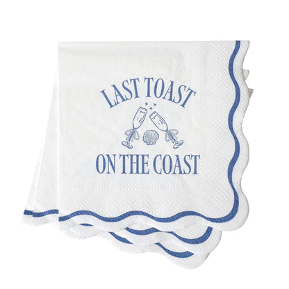 White napkin with blue text: LAST TOAST ON THE COAST and champagne graphics on a white background.