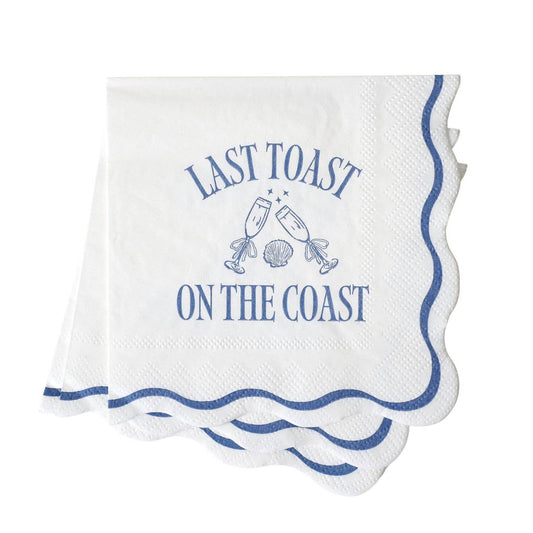 White napkin with blue text: LAST TOAST ON THE COAST and champagne graphics on a white background.