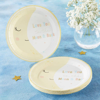 Paper plates with a smiling crescent moon design and 'Love You to the Moon & Back' text on a blue surface with flowers.