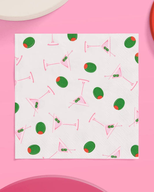 Patterned paper beverage napkin with cocktail design on a pink background.