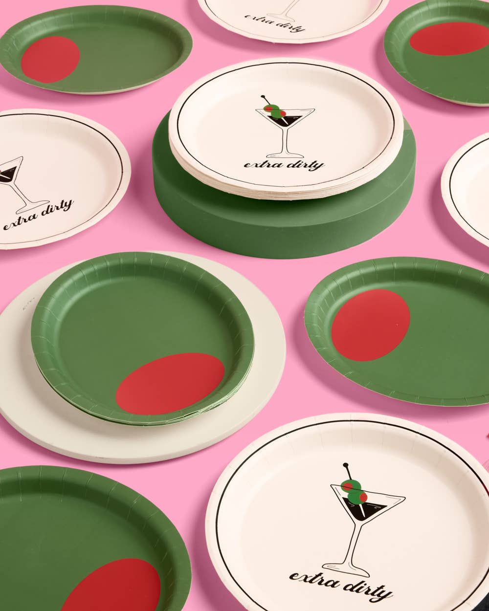 Set of paper plates with martini themed designs on a pink background.