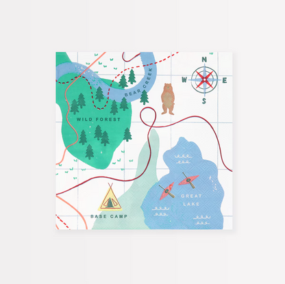 A folded paper napkin with an illustrated map design, featuring names like 'Wild Forest' and 'Base Camp', with a compass rose at the top.
