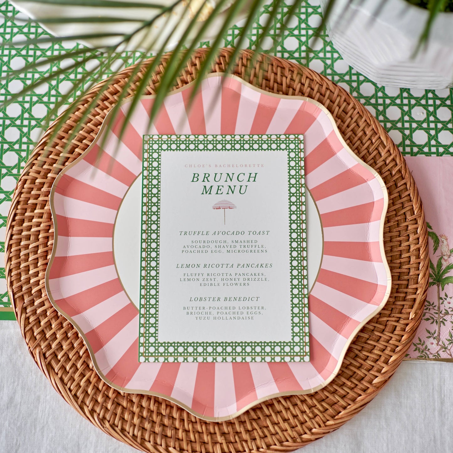 Pink and white striped plate with a brunch menu on a woven placemat.