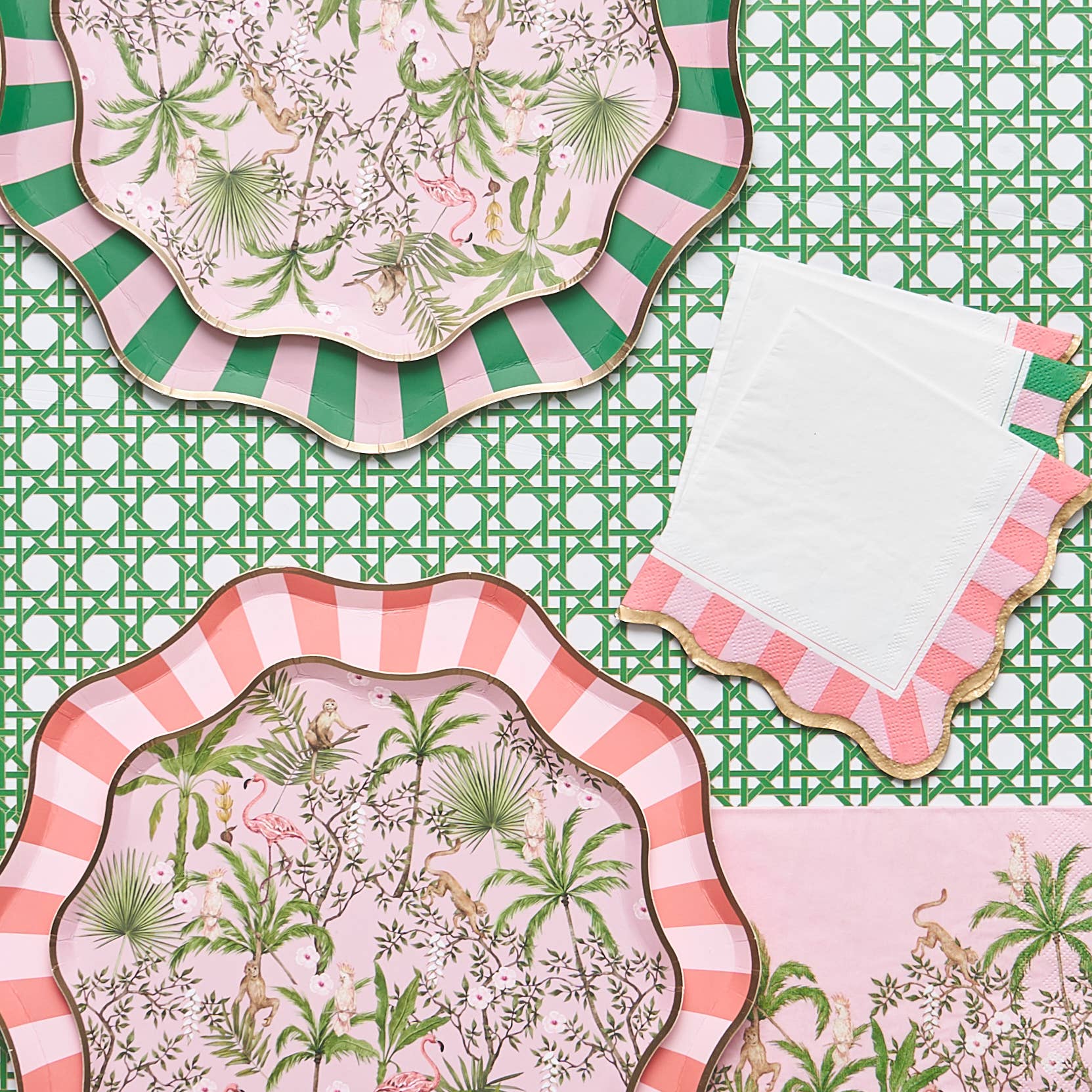 Decorative plates with tropical and striped designs on a green rattan patterned table runner.