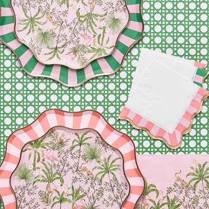Decorative plates with tropical and striped designs on a green rattan patterned table runner.
