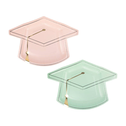 Two graduation cap-shaped paper plates, one pink and one green, on a white background.