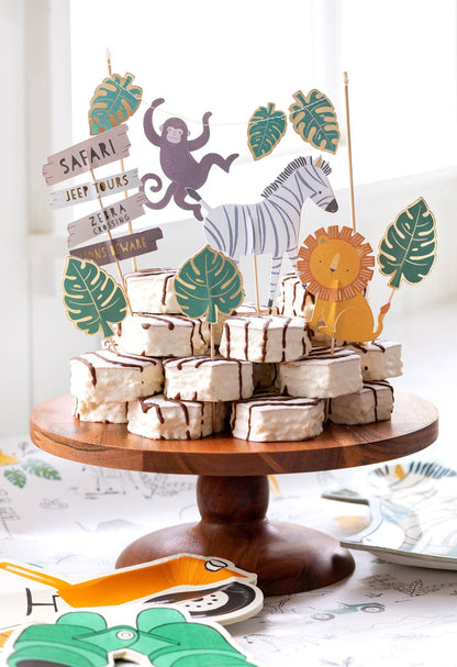 Wooden cake stand with animal-themed cake decorations on a table.