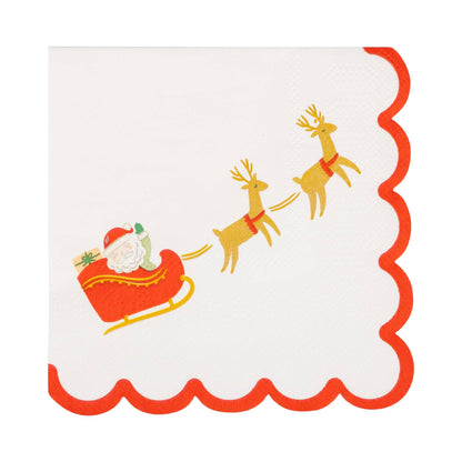 Cocktail napkin with Santa Claus in a sleigh and reindeer design with red scalloped trim.