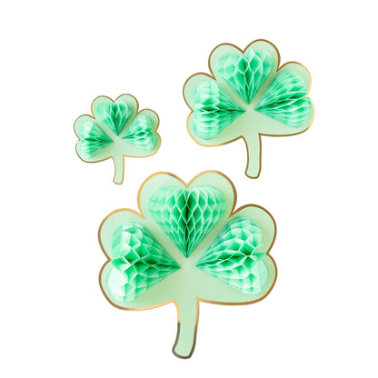Three green tissue honeycomb shamrocks of varying sizes designed as hanging party decorations.