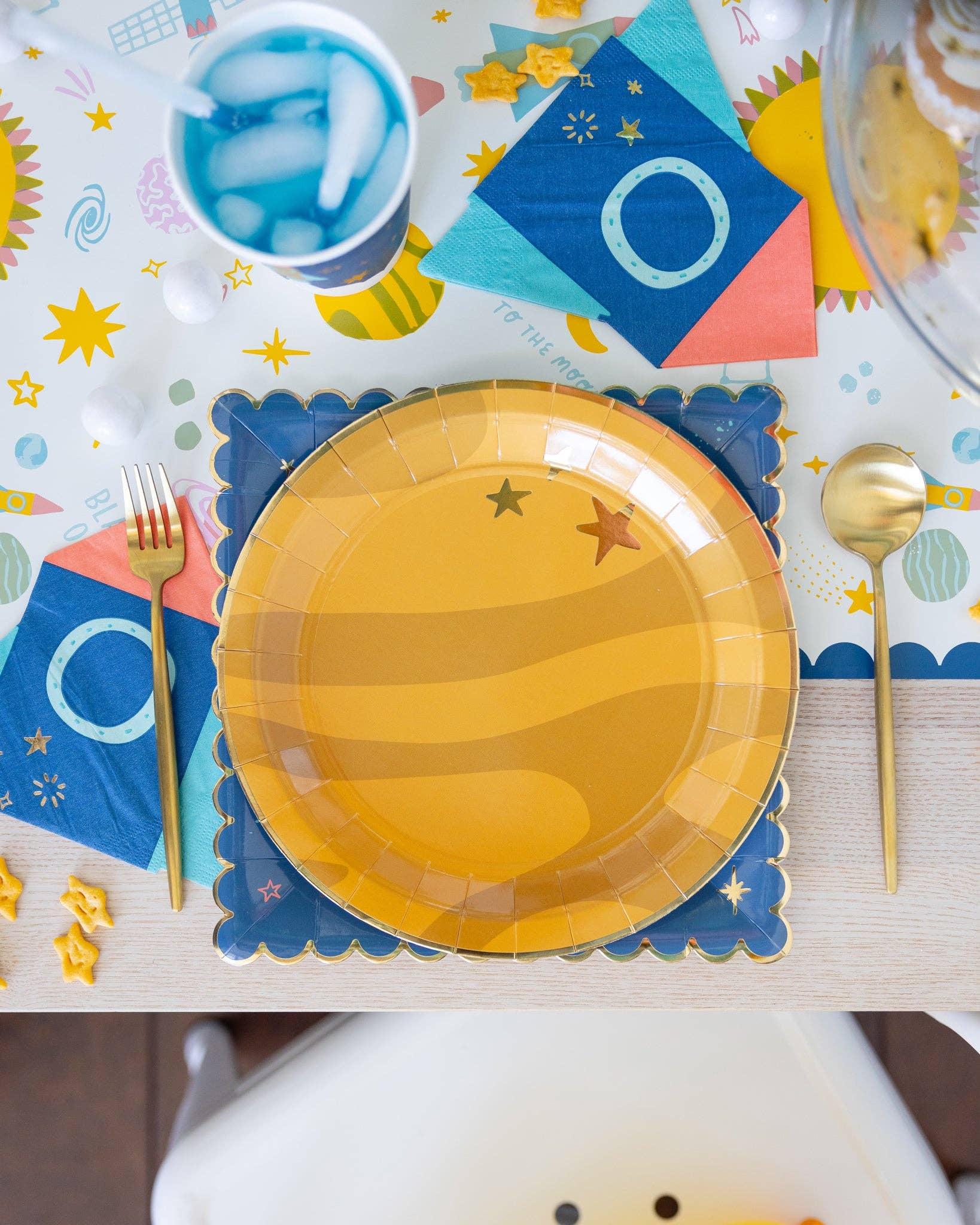 Yellow planet-shaped plate on a colorful table setting with star decorations.