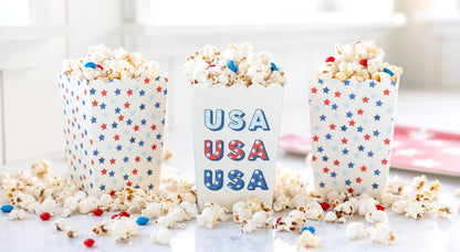 Three popcorn buckets with star patterns and 'USA' text on a white surface.