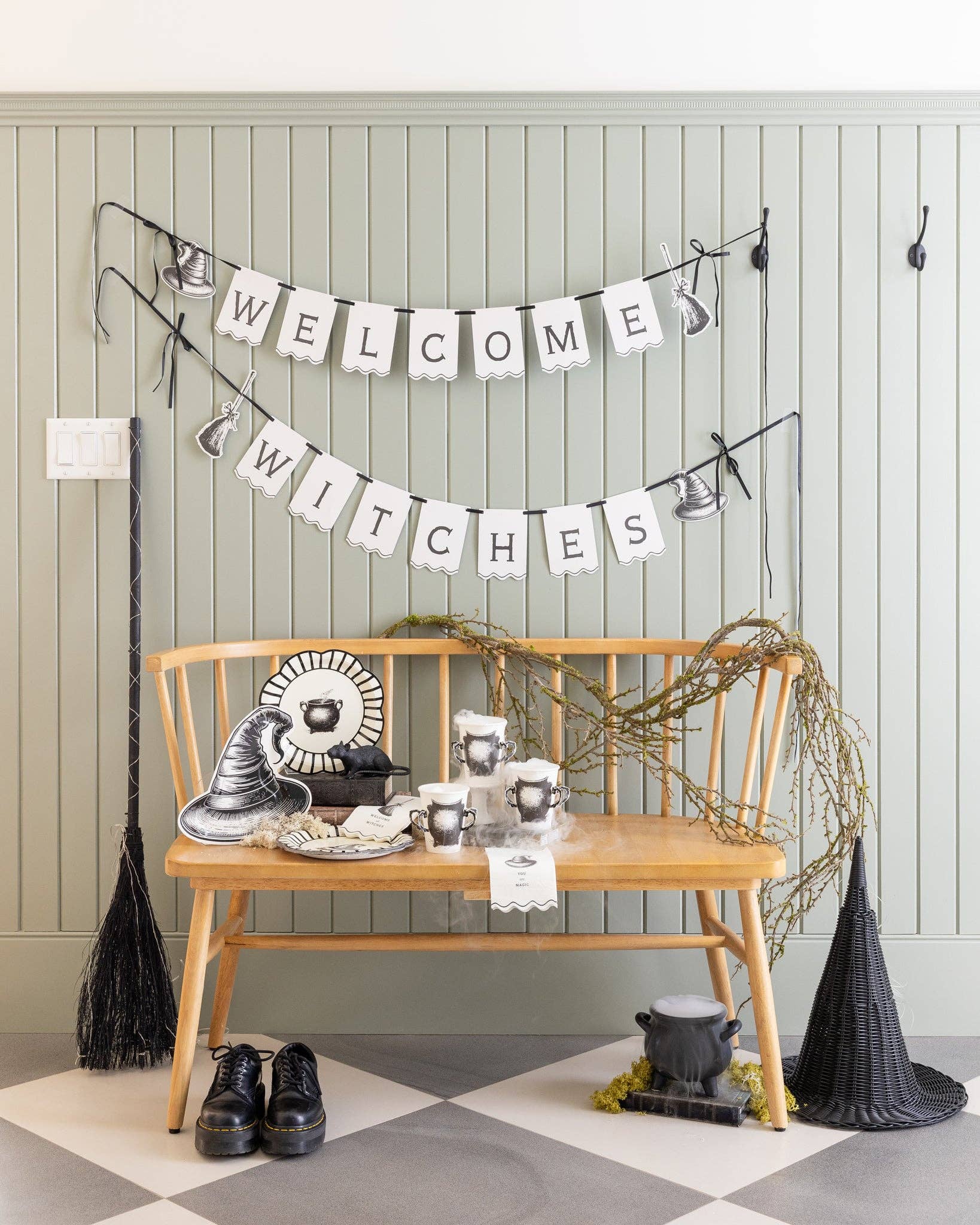 Halloween-themed room with 'Welcome Witches' banner, broom, and witch hats.