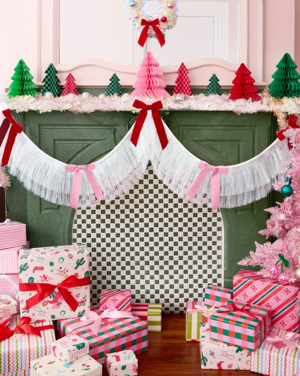 Decorative Christmas scene with presents, trees, and a mantel decorated with a white fringe garland with ribbons.