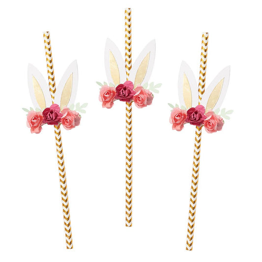 A set of three paper straws adorned with floral bunny ears in white and gold, with pink and green flowers.