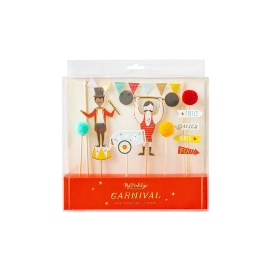 A set of cake toppers with carnival themed figures including a clown, a tightrope walker, and a merry-go-round operator, all made of cardboard and adorned with gold foil accents, packaged in a clear plastic box.