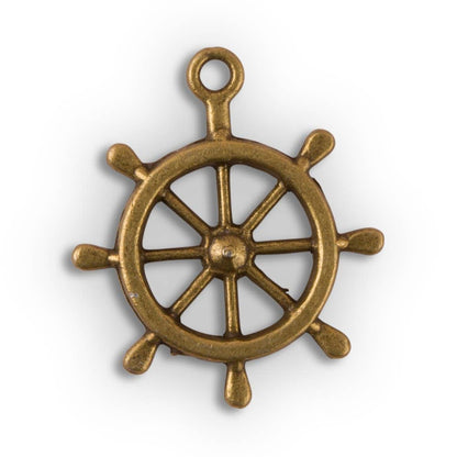 A gold-colored metal boat wheel charm with a antique brass finish.